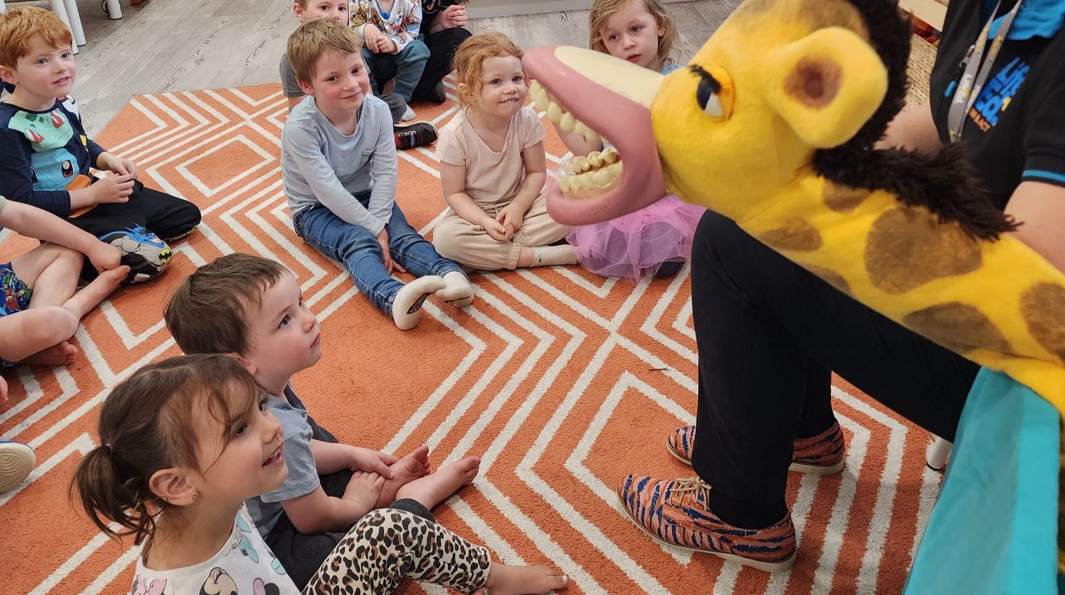 Children listening to a story on an indoor playmat