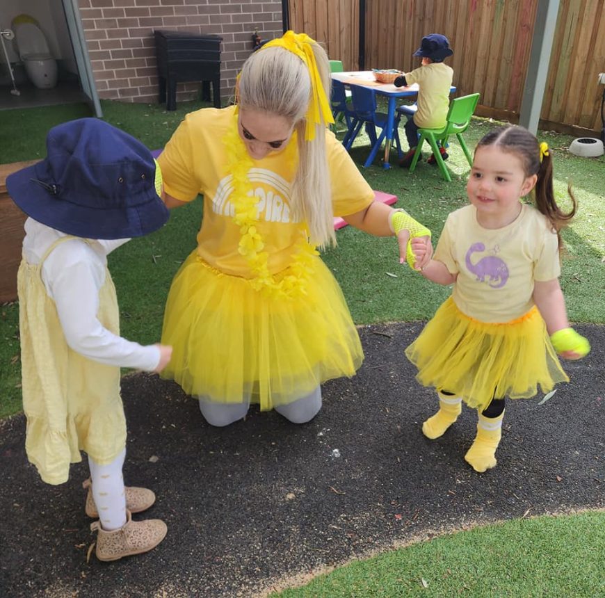 One of our educators and two children playing outside in Eglinton